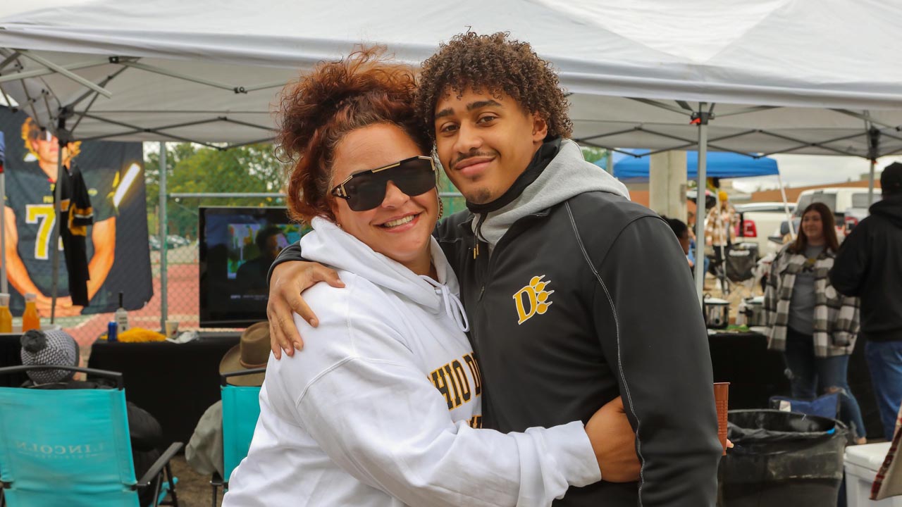 Two ODU Panthers standing together, smiling outside the stadium.