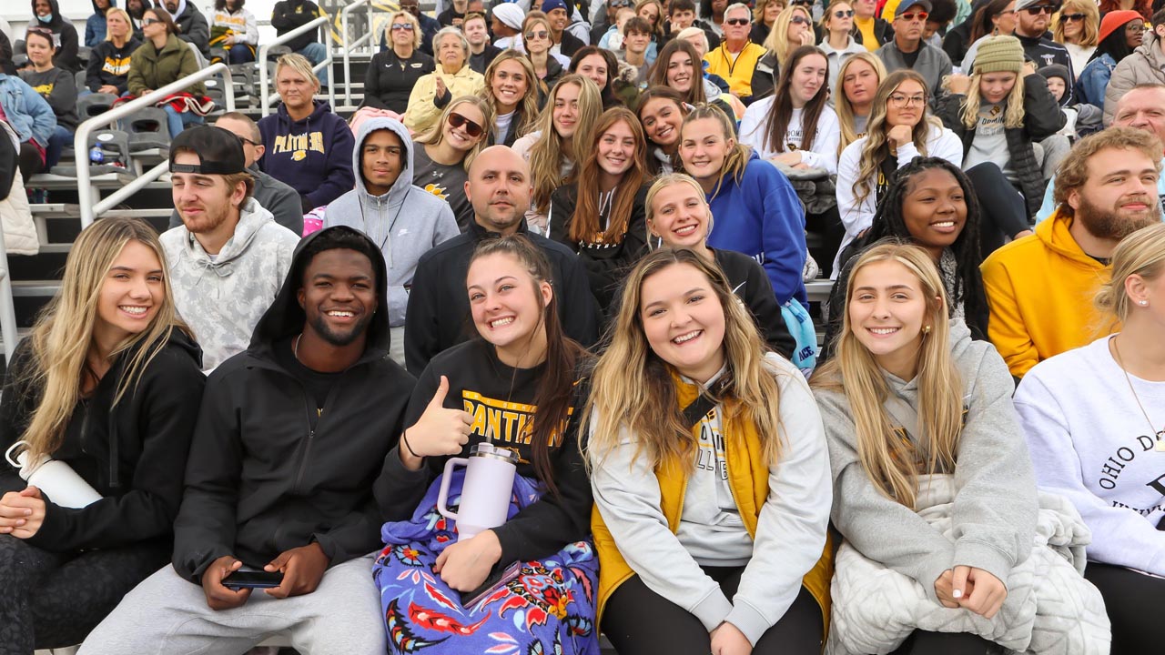 Rows of Panthers cheer on ODU and smile for the camera.