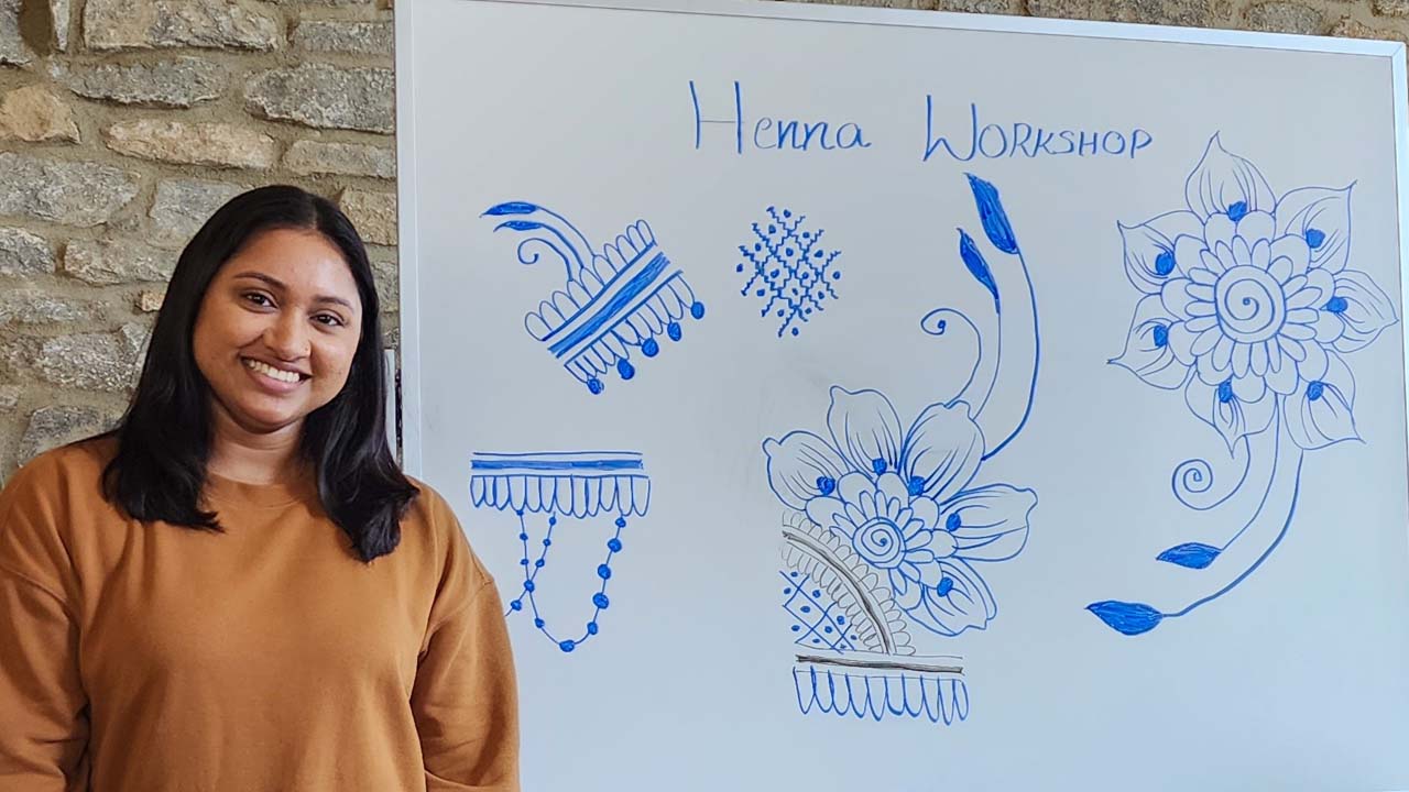A student poses with Henna designs at an IEW Henna workshop.