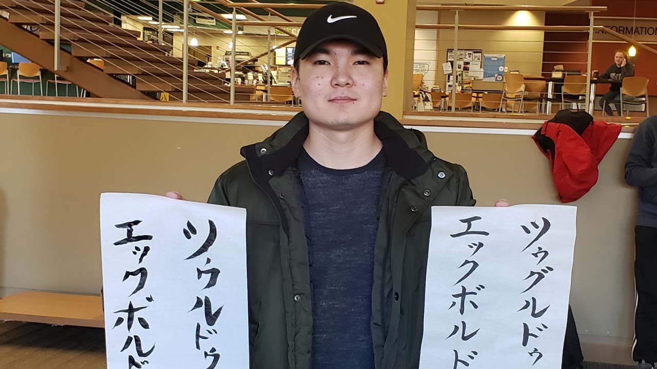 A student displays their calligraphy from an IEW workshop.