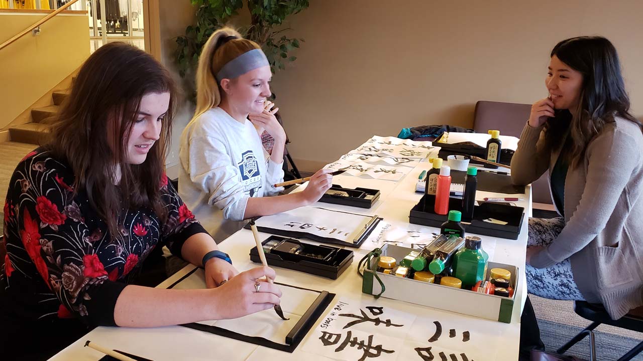 Students and staff take part in a Chinese/Japanese calligraphy workshop.