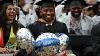 Graduates in caps and gowns smiling and laughing, holding balloons that read "Congratulations"