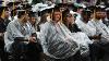 Graduates wearing rain ponchos during the ceremony as it begins to rain.