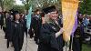 ODU graduates carrying banners lead their fellow students as they enter the Erskine Oval during the Academic Processional for Commencement on May 4, 2024.