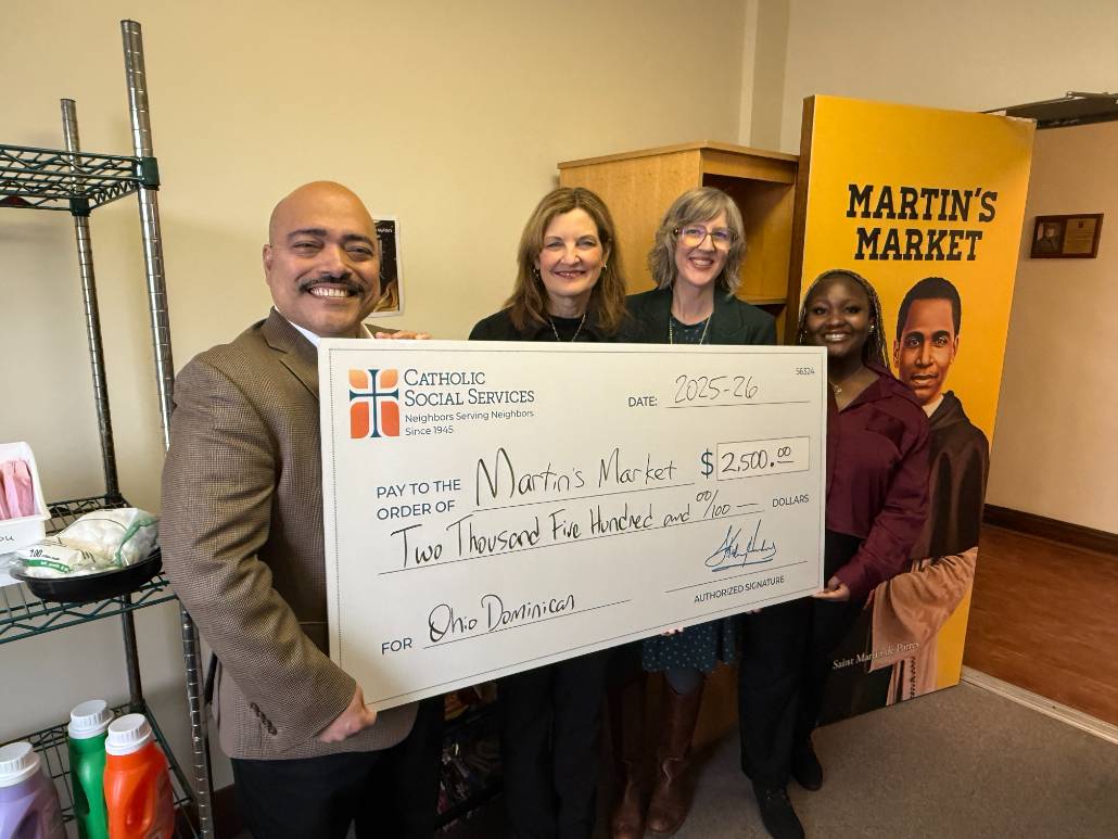 Ezra Escudero of Catholic Social Services presents a grant check to ODU President Dr. Shonna Riedlinger, Emily Strand, Director of Campus Ministry, and student worker Hajaratu Kamara.
